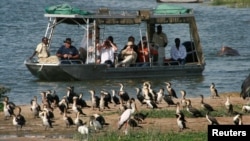 FILE - Tourists look at birds at the Queen Elizabeth National Park, western Uganda, April 2, 2009. The Ugandan government says gunmen have abducted a female American tourist and her driver inside the park April 2, 2019.