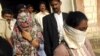 Face covered Shaheen Dhada, left, and Renu Srinivas, come out of a court in Mumbai, India after being arrested for their Facebook post, November 20, 2012.