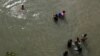 Migrantes lavan ropa en el río Grande cerca de un improvisado campamento ocupado por solicitantes de asilo en el puente internacional Gateway en Matamoros, Tamalipas, México, el 28 de octubre de 2019.