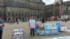 Abdurehim Gheni con fotografías de sus familiares y otros uigures desaparecidos en la plaza Dam de Ámsterdam en julio del 2019.
