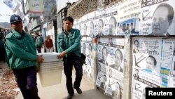Police officers carry ballot boxes to a polling center in Dhaka for parliamentary elections, Jan. 4, 2014.