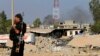 FILE - A Kurdish Peshmerga fighter walks past a house destroyed by American air strikes in Zummar, Iraq, near Mosul on Sept. 15, 2014. At least five rockets were launched from Zummar toward a U.S. military base in Syria on April 21, 2024.