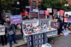 FILE - Families of COVID-19 victims who passed away in New York nursing homes protest Gov. Andrew Cuomo's response to coronavirus cases in care centers, in the Brooklyn borough of New York, Oct. 18, 2020.