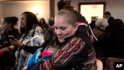 Jessie "Little Doe" Baird (R) abraza a un miembro de la audiencia luego de la celebración en Old Indian Meeting House, en Mashpee, Massachusetts, el 18 de noviembre de 2017.
