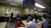 An Indian woman, foreground left, waits to send a telegram at Bharat Sanchar Nigam Limited (BSNL), a state-run telecom company in Bangalore, India, June 14, 2013.