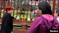 Mujeres colocan flores en honor al capitán de corbeta Rafael Acosta Arévalo, en el exterior del edificio del Comando General de la Marina en Caracas, Venezuela, el 1 de julio de 2019.