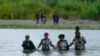 Migrantes haitianos vadean el río Tuquesa después de caminar por el Tapón del Darién, el miércoles 4 de octubre de 2023, en Bajo Chiquito, Panamá. 
