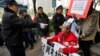 A policeman points to a supporter of Southern Weekly newspaper in a wheelchair before taken him away during a protest near the headquarters of the newspaper in Guangzhou, Guangdong province, China, Jan. 10, 2013. 