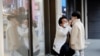 A man and a boy wear masks to prevent contracting a new coronavirus at Myeongdong shopping district in Seoul, South Korea, Feb. 20, 2020. 
