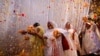 Widows throw flowers into the air during a holi celebration at the Meera Sahavagini ashram in Vrindavan in the northern Indian state of Uttar Pradesh, Mar. 24, 2013.