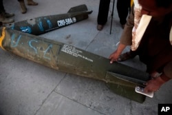 FILE - A Yemeni man displays an American-made CBU 58A/B, cluster bomb, in a police compound in Sanaa, Yemen, Oct. 5, 2016.