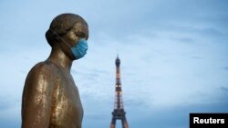 La estatua de oro en la plaza Trocadero, cerca de la torre Eiffel, usa una máscara protectora durante el brote de la enfermedad por coronavirus (COVID-19) en París, Francia.