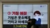People wearing face masks pass by an electric screen about precautions against the illness COVID-19 in Seoul, South Korea, Tuesday, Feb. 18, 2020. 