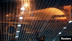 Un Boeing 777 de Malaysia Airlines vistro através de un vidrio en el aeropuerto de Kuala Lumpur.