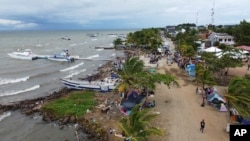 Migrantes se reúnen en Necoclí, Colombia, un punto de parada para los migrantes que toman embarcaciones hacia Acandi, que conduce al Tapón del Darién, el 13 de octubre de 2022.