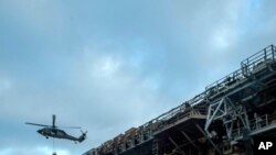 Sailors prepare to board the amphibious assault ship USS Bonhomme Richard to fight an ongoing fire at Naval Base in San Diego, Calif. on July 14, 2020. 