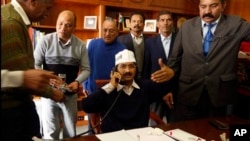 Aam Aadmi Party leader Arvind Kejriwal talks on phone as he assumes office of the Chief Minister of Delhi, New Delhi, Dec. 28, 2013.
