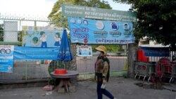 រូបឯកសារ៖ ស្ត្រីម្នាក់ពាក់ម៉ាស់ដើរកាត់សាលារៀនមួយដែលបានបិទទ្វារ ខណៈមានការបារម្ភពីការឆ្លងរាតត្បាតនៃជំងឺកូវីដ ១៩ នៅទីក្រុងភ្នំពេញ ថ្ងៃទី១២ ខែវិច្ឆិកា ឆ្នាំ២០២០។