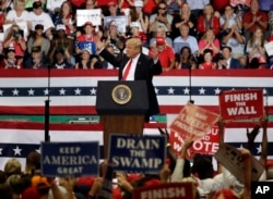FILE - President Donald Trump reacts as supporters wave signs during a rally, Oct. 31, 2018, in Estero, Florida.