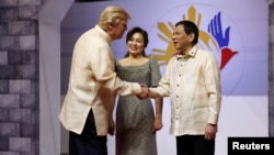 El presidente de Estados Unidos Donald Trump estrechaba las manos con el presidente de Filipinas Rodrigo Duterte mientras llega a la gala que conmemora el 50 aniversario de la Asociación de Naciones del Sudeste Asiático (ASEAN) en Manila, el 12 de noviembre de 2017.