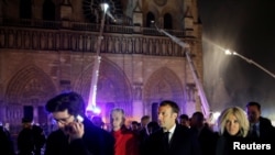 El presidente francés Emmanuel Macron y su esposa Brigitteen las afueras de Notre Dame mientras los bomberos intentan contener el fuego. Photo: Reuters.