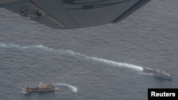Buques de la Armada ecuatoriana rodean a un barco de pesca, detectado en un corredor internacional que limita con la zona económica exclusiva de las Islas Galápagos, en el Océano Pacífico, el 7 de agosto de 2020.
