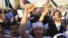 Jordanians and Syrian refugees protest the killing of at least 108 people in the Syrian town of Houla last Friday, outside the Syrian embassy in Amman, Jordan, May 30, 2012. 