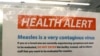FILE - A notice for a health alert about measles is posted on the door of a medical facility in Seattle, Washington, Feb. 13, 2019.