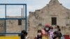 Visitantes posan frente a la fachada del Álamo, en San Antonio, Texas, mientras portan tapabocas. Los casos de COVID-19 se han elevado en Texas y el gobernador animó a las personas a usar tapabocas en espacios públicos.