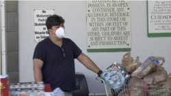 Un hombre, con mascarilla y con el carrito lleno, tras salir de hacer la compra en un supermercado de Miami Beach (Florida).