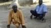 Polio sufferers Yusuf Umar, right, and Aminu Ahmed use wooden blocks to propel themselves through the dusty streets of Kano, Nigeria, November 28, 2008. 