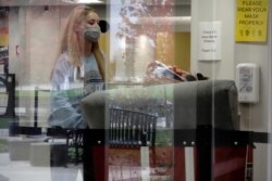 ARCHIVO - Una estudiante de la Universidad Wisconsin-Madison, mueve sus pertenencias del dormitorio donde residía, ante una orden de las autoridades de la escuela por un brote de coronavirus en Madison.