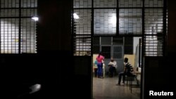 Trabajadores electorales esperan al cierre de la mesa electoral durante los comicios estatales y locales, en Caracas, el 21 de noviembre de 2021.