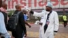 FILE - A health worker checks people's temperatures as they disembark a plane at the airport in Kinshasa, Congo, June 2, 2018.