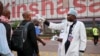 FILE - A health worker checks people's temperatures as they disembark a plane at the airport in Kinshasa, Congo, June 2, 2018.