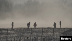 ARCHIVO: Un grupo de migrantes es detenido por miembros de la Guardia Nacional de Estados Unidos en Eagle Pass, Texas, visto desde Piedras Negras, México, el 4 de febrero de 2024.