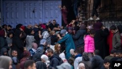 Palestinos tratan de comprar pan en una panadería en Rafah, en la Franja de Gaza, el domingo 18 de febrero de 2024. Agencias internacionales de ayuda dicen que Gaza sufre desabastecimiento de comida, medicamentos y otros suministros básicos.