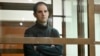 FILE - Wall Street Journal reporter Evan Gershkovich stands in a glass cage in a courtroom at the Moscow City Court, in Moscow, Russia, on Dec. 14, 2023. 