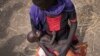 Adel Bol, 20, cradles as she her 10-month-old daughter Akir Mayen at a food distribution site in Malualkuel in the Northern Bahr el Ghazal region of South Sudan.