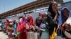 FILE - Displaced Somali girls who fled the drought in southern Somalia stand in a queue to receive food handouts at a distribution center in a camp in Mogadishu, Somalia, Feb. 25, 2017.