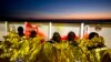 FILE - Sub-Saharan migrants cover themselves with a heating blanket at the deck of the Golfo Azzurro boat after been rescued from a rubber boat by members of Proactive Open Arms NGO, at the Mediterranean sea, north of Sabratha, Libya, Jan. 27, 2017.