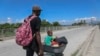 Un hombre empuja a un niño en una carretilla en Pont-Sonde, Haití, el 7 de octubre del 2024, días después de una matanza en esa área.