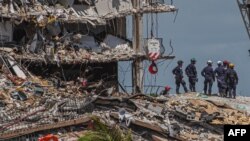 En esta foto de archivo, los equipos de búsqueda y rescate buscan posibles sobrevivientes en el edificio de condominios Champlain Towers South, de 12 pisos, parcialmente derrumbado,el 27 de junio de 2021 en Surfside, EE. UU.
