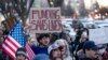 FILE - People protest a funding freeze of federal grants and loans following a push from President Donald Trump to pause federal funding, near the White House in Washington, Jan. 28, 2025.