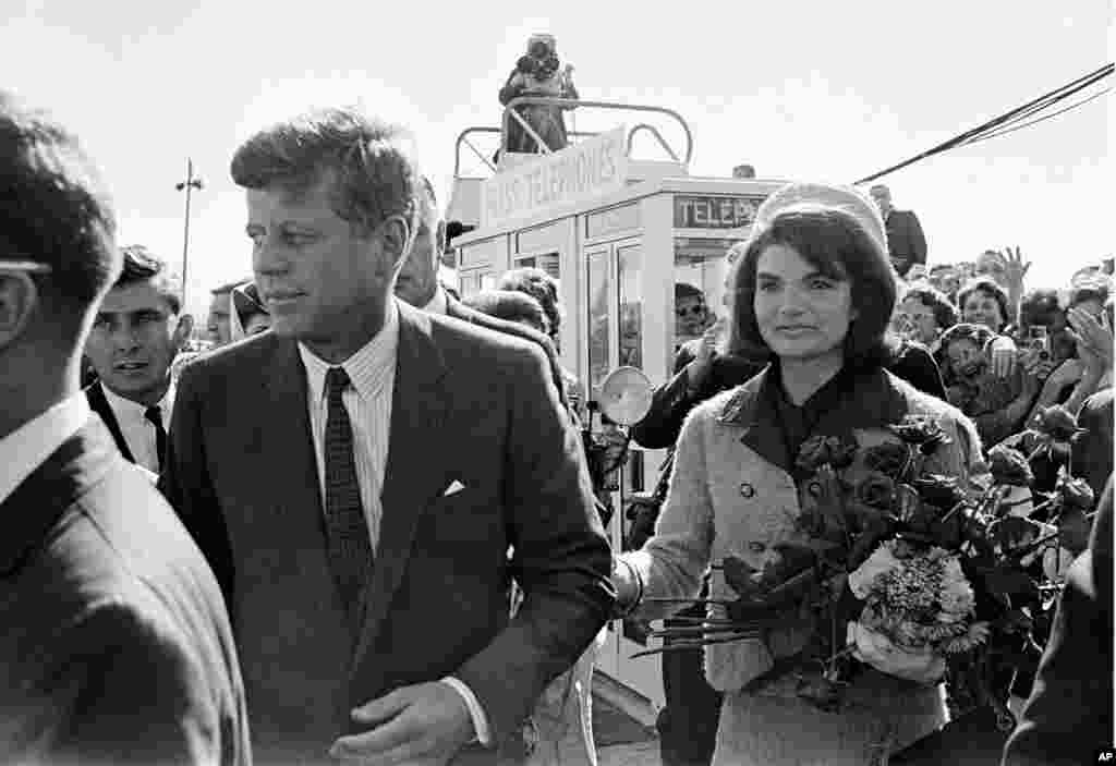 El presidente John F. Kennedy y su esposa Jacqueline Kennedy reciben los saludos de una entusiasmada multitud a su llegada al campo Dallas Love, Texas, el 22 de noviembre de 1963.