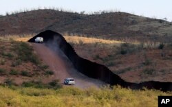 Patrulleros federales vigilan el muro fronterizo en Naco, Ariz., Oct. 2, 2012. National Guard contingents in U.S. states that border Mexico say they are waiting for guidance from Washington to determine what they will do following President Donal