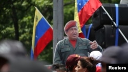 Un recorte de cartón de tamaño real del fallecido presidente venezolano Hugo Chávez se encuentra en medio de la multitud durante una manifestación en apoyo de Nicolás Maduro y para conmemorar el 1 de Mayo en Caracas, Venezuela. REUTERS