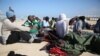 FILE - African migrants rest after their rescue by the Libyan Coast Guard west of Tripoli, Dec. 21, 2015.