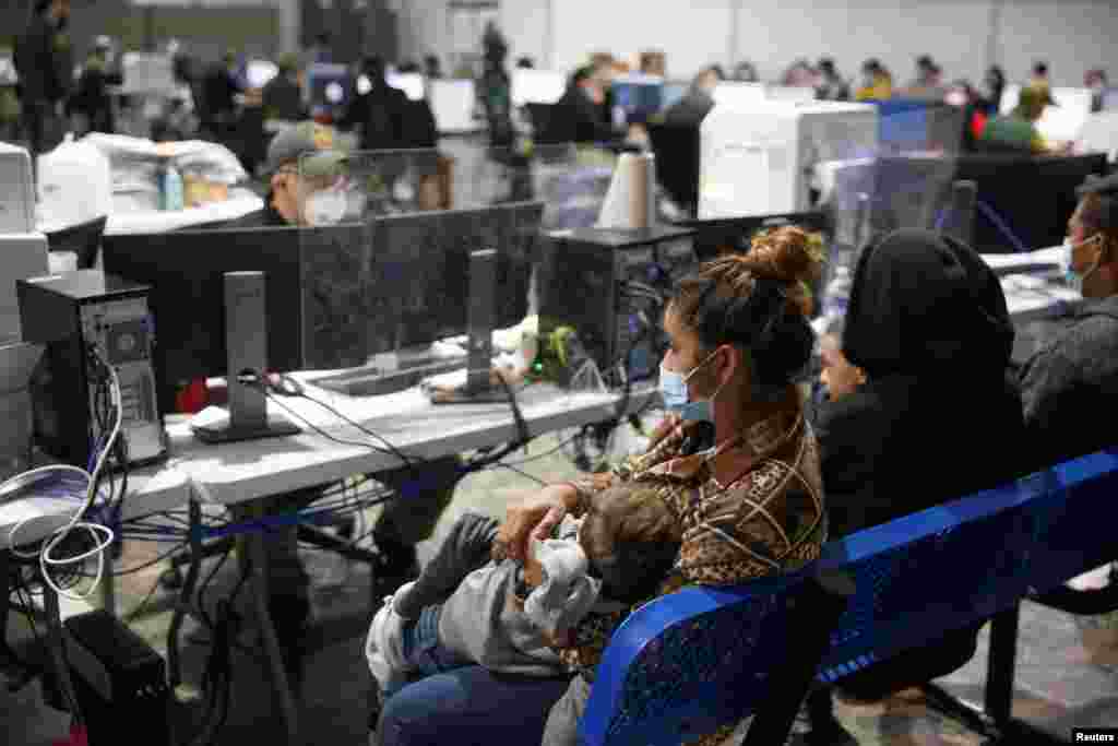 Las familias migrantes esperan ser interrogadas en el &#225;rea de admisi&#243;n preliminar del centro de detenci&#243;n del Departamento de Seguridad Nacional de Donna.