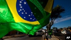 Un vendedor ondea una bandera brasileña en Fortaleza, Brasil.